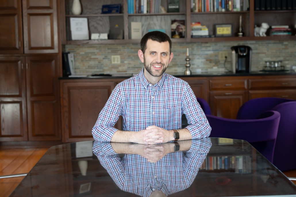 Kevin Flint, CFP®, posing for a photo at a conference table at Hess Financial in Harrisonburg, VA.